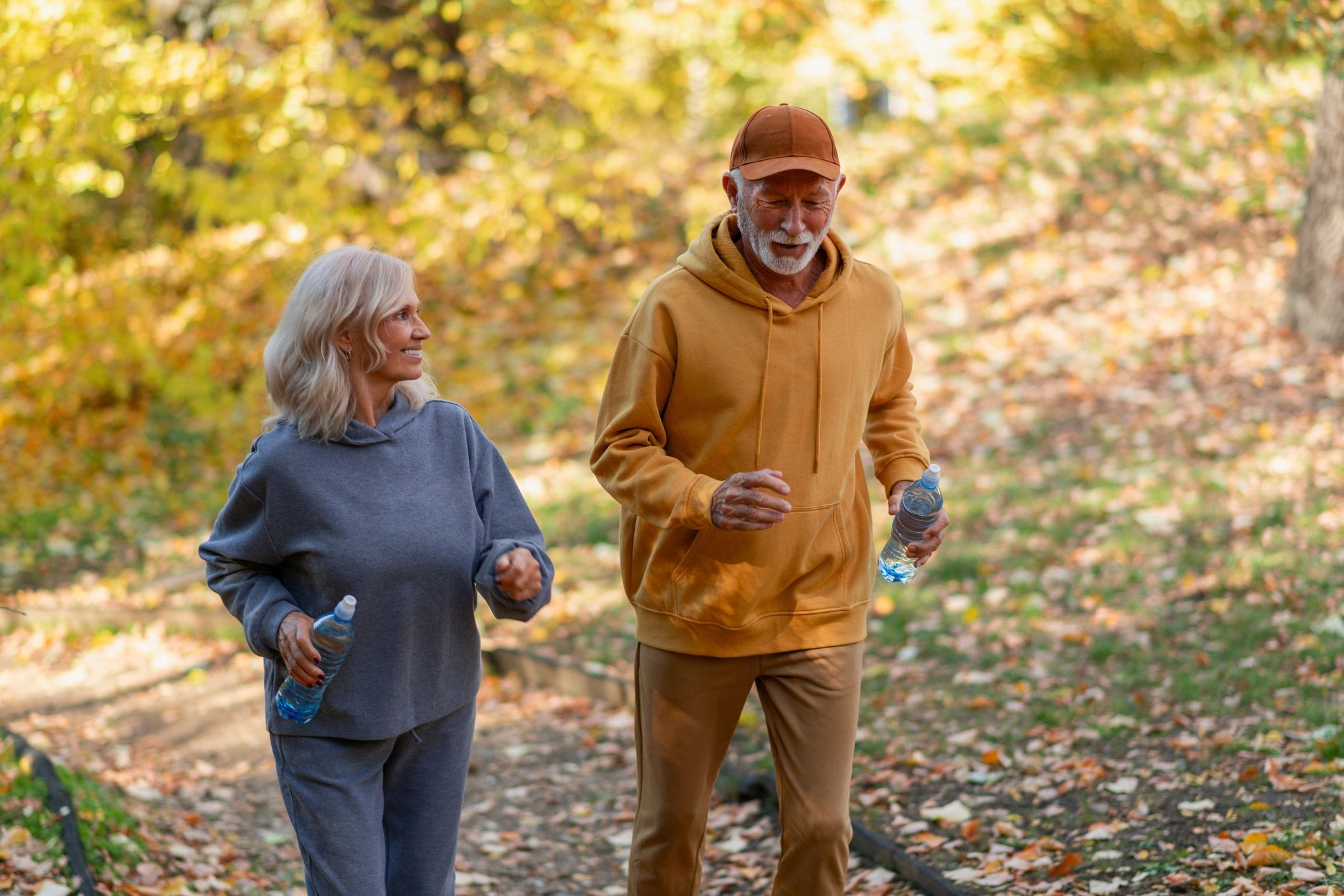 Seniors jogging outdoors in autumn park